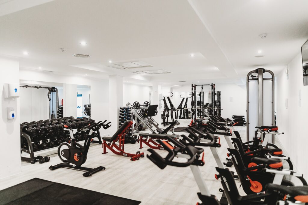 white gym with spin bikes and other gym equipment